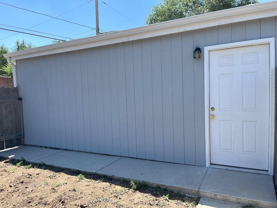 Entrance to garage in fully fenced backyard.
