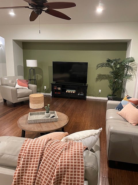Open living room with 65 in. Smart TV, comfortable seating, games and books.