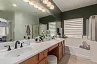 Master 5-piece bathroom, with dual rain shower heads, soaking tub, vanity mirror & bench and full-length mirrors.