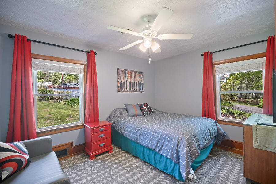 Front bedroom with love seat, dresser and TV