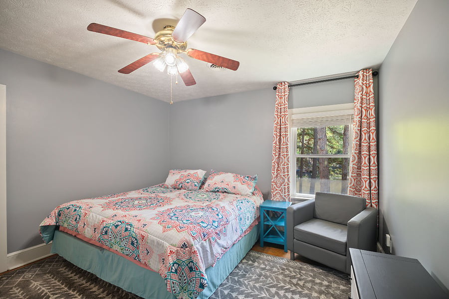 Master bedroom with chair, dresser TV, TV has Digital Recorder with Cable