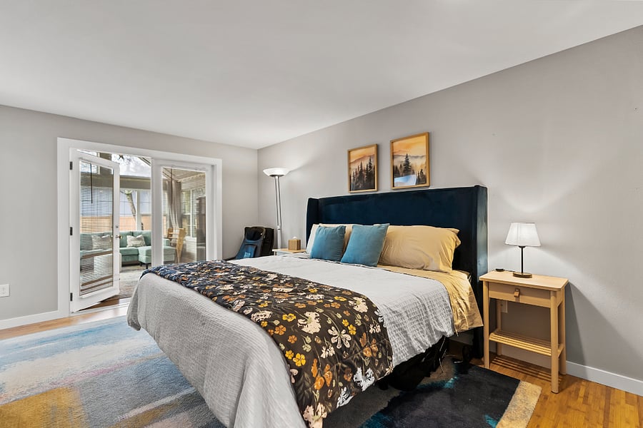 Primary bedroom with adjustable King bed, access to sunroom, and on-suite full bath