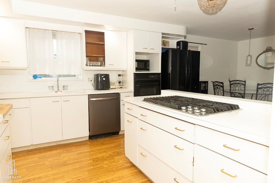 Large dream white eat-in kitchen with with abundance of cabinet.