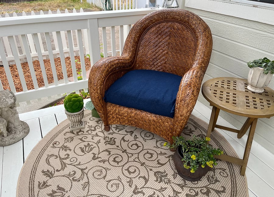 Covered front porch with wicker lounge chair.