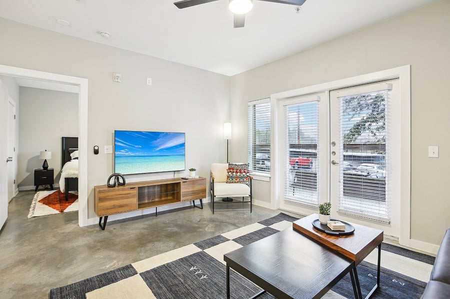 Living room, primary bedroom door, and backdoor that goes to the large, private patio