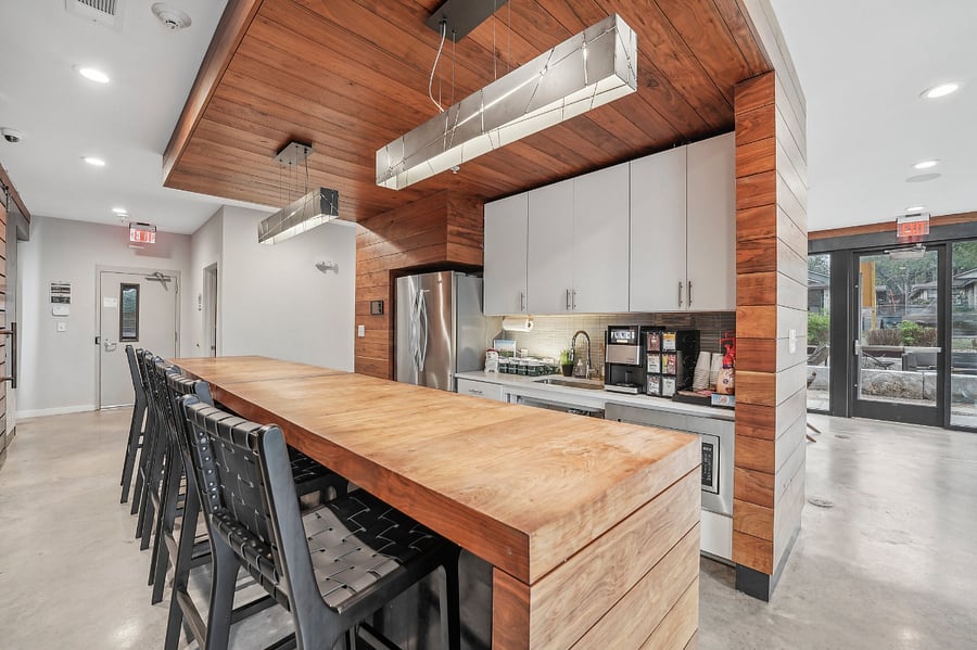 Large indoor community kitchen area with coffee machine and refrigerator