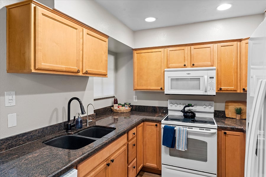 Kitchen equipped with full-sized range, microwave, dishwasher, and refrigerator for full-sized living