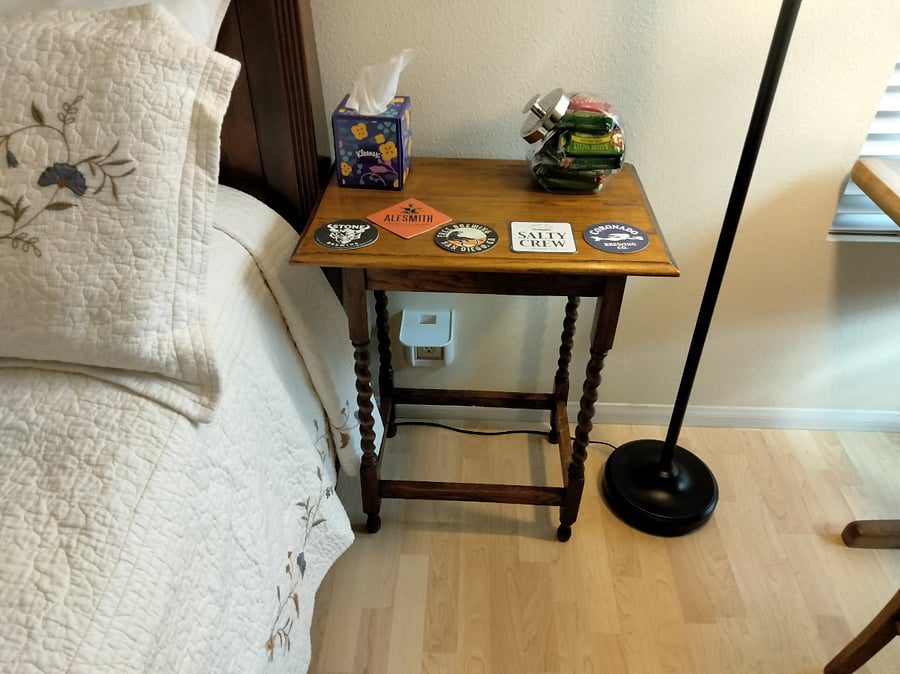 Bedside table with phone charging shelf underneath.