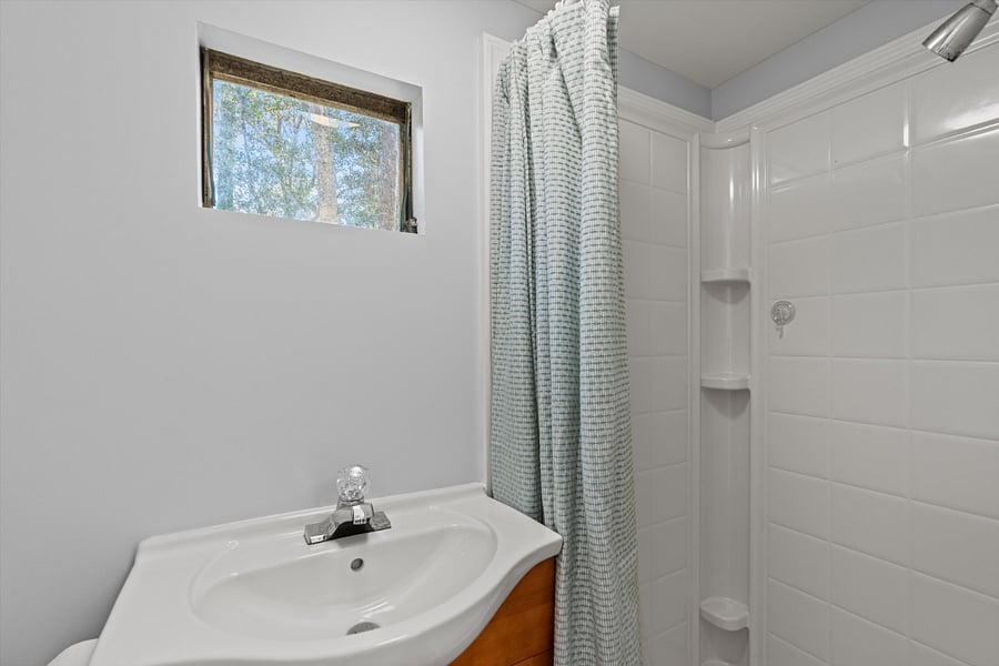 Bathroom with shower, sink, and toilet attached to the second bedroom/office