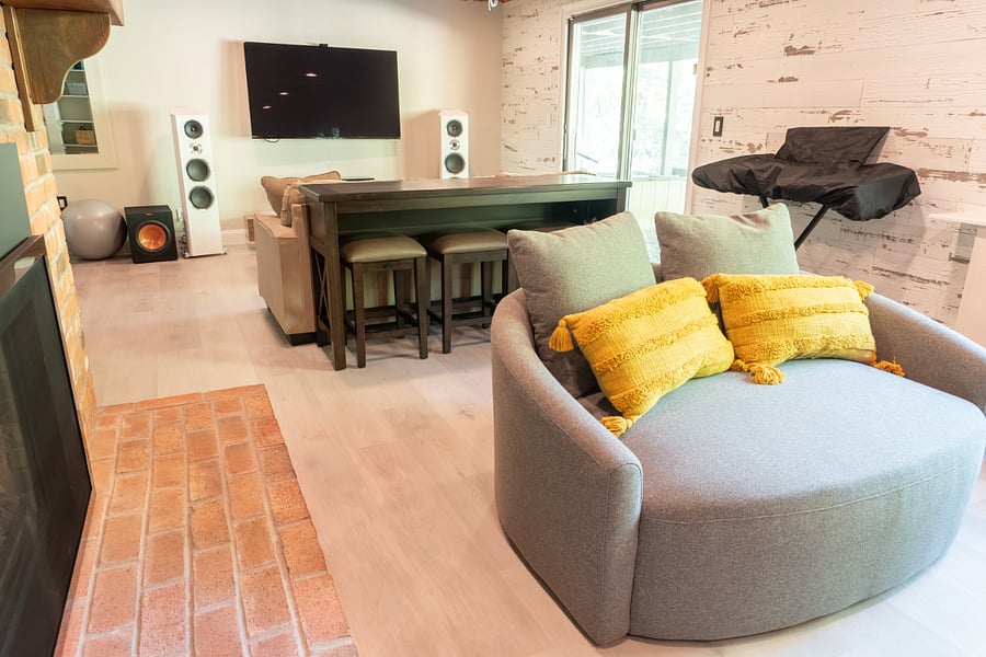 Partially finished basement with gas fireplace, work area, seating, electric keyboard and media system