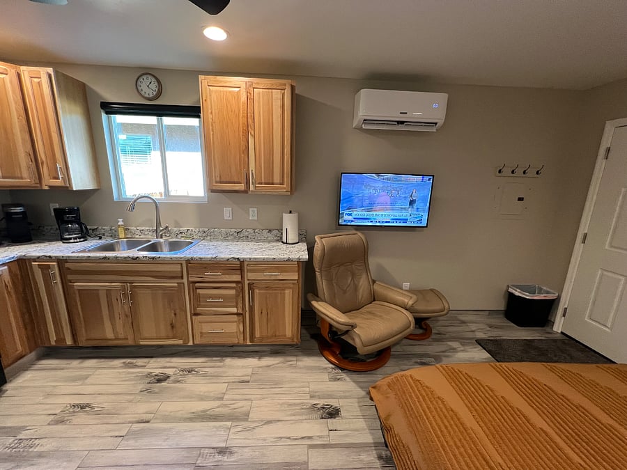Cozy studio with a quiet mini-split for efficient heating and cooling, full-size stainless steel kitchen appliances, and a vibrant smart TV. Bright, airy, and modern, its an inviting retreat with ample counter space and stylish charm.

