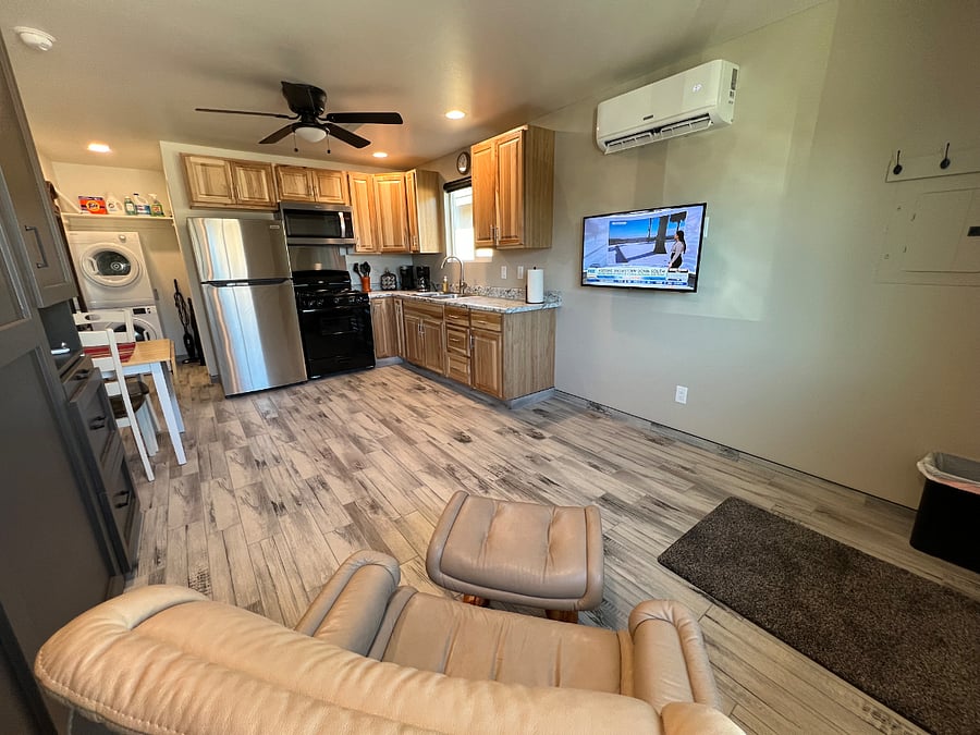 Cozy studio with a quiet mini-split for efficient heating and cooling, full-size stainless steel kitchen appliances, and a vibrant smart TV. Bright, airy, and modern, its an inviting retreat with ample counter space and stylish charm.

