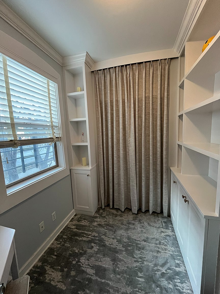 Super cozy carpeted book nook with writing desk, built-in bookshelves, and storage closet.