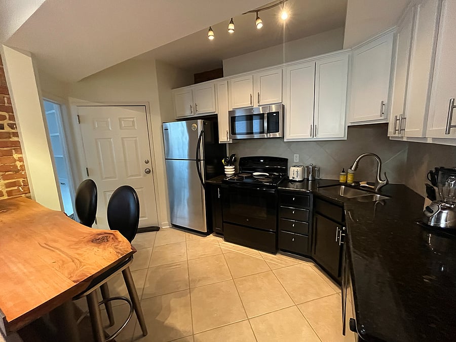Fully stocked kitchen with pots, pans, cookware, dinnerware, silverware, glassware, utensils, coffee press, electric tea kettle, blender, toaster, dishwasher, and more.
