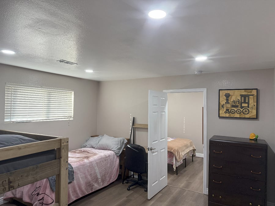 Bedroom 1 with Dresser, Workstation and w/ Bedroom 2 through Doorway