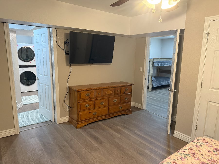 Master Bedroom TV & Dresser w/ Bedroom 1 on the right and Bathroom with Washer & Dryer on the left
