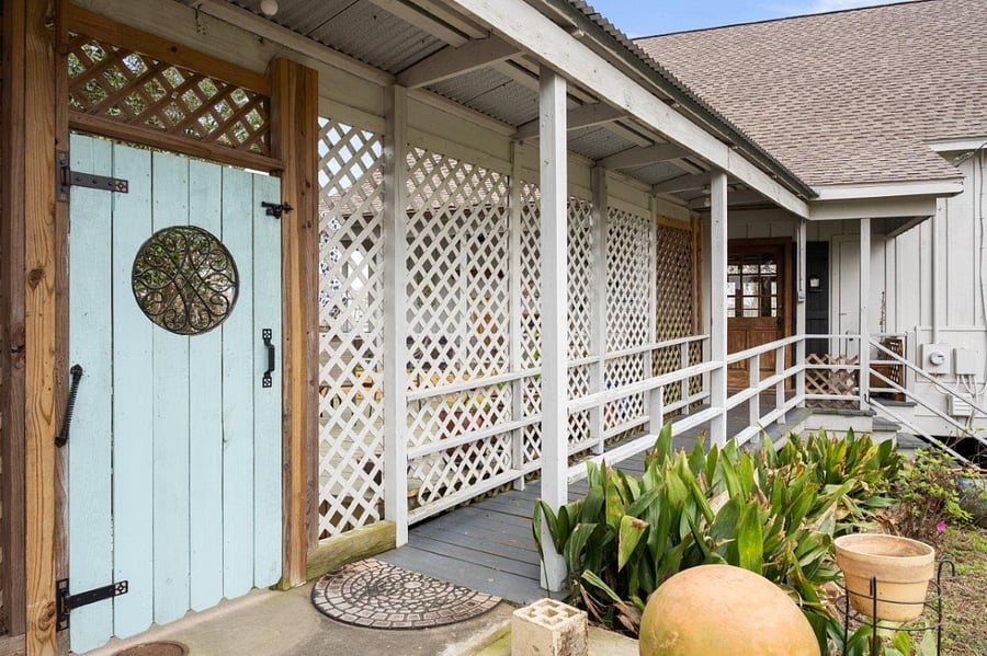 Covered ramp leading from carport to back door. Blue door leads to barbque deck.