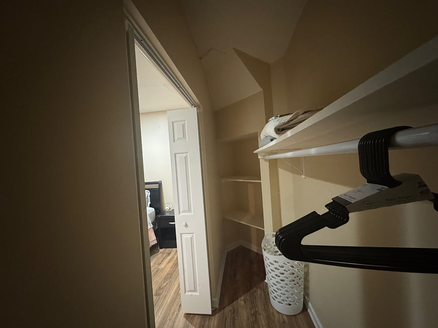 Bedroom #2 Closet: Long galley-style walk-in with additional shelving, hamper, hangers, extra blanket, and extra linen