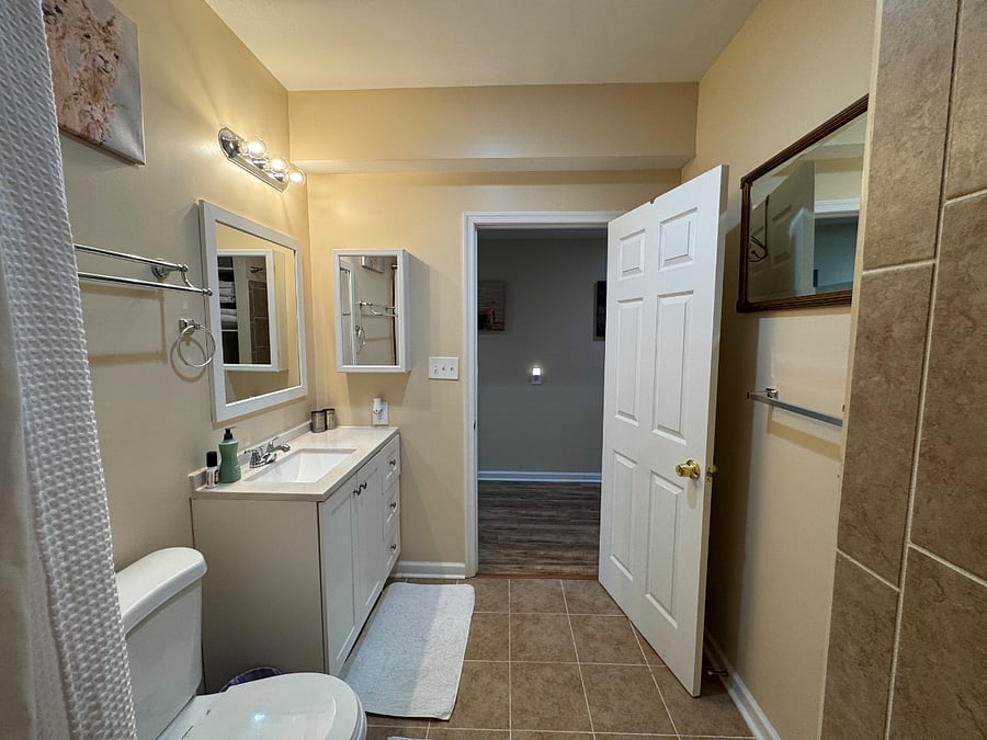 Bathroom (view 2); Reverse view; Medical cabinet, sink storage, 3 bath towel bars, hand towel ring, and over door hanging hooks