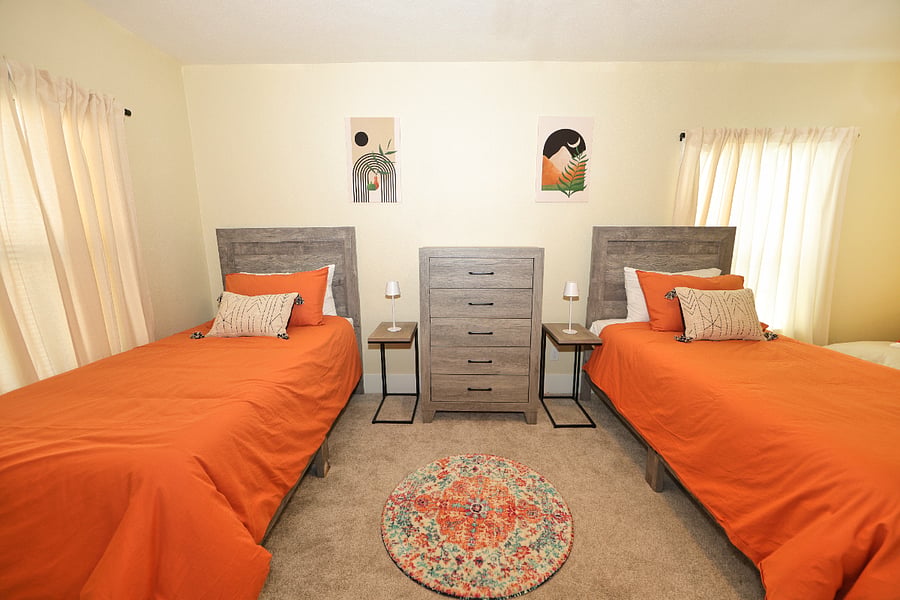 Upstairs bedroom has two twin beds, chest of drawers, and reading nook complete with a comfy chair.