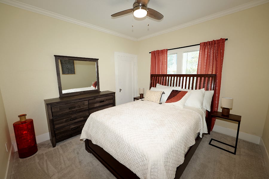 Second bedroom located on first floor has queen size bed with room darkening curtains dresser and mirror. All rooms have hangers and steam iron.