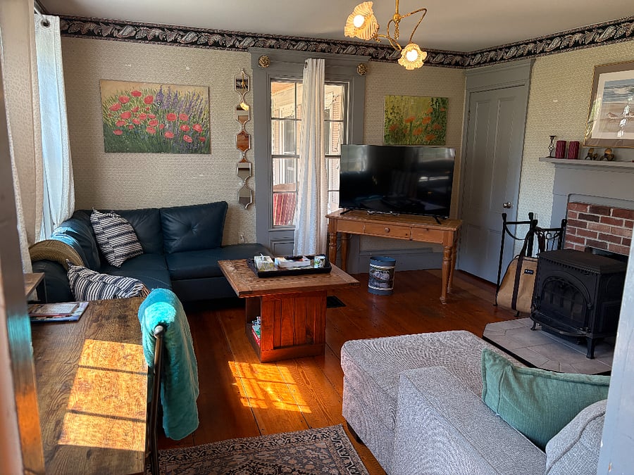 Living room with tv, desk and wood stove