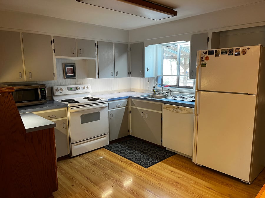 Kitchen with full size refrigerator, range, and dishwasher.