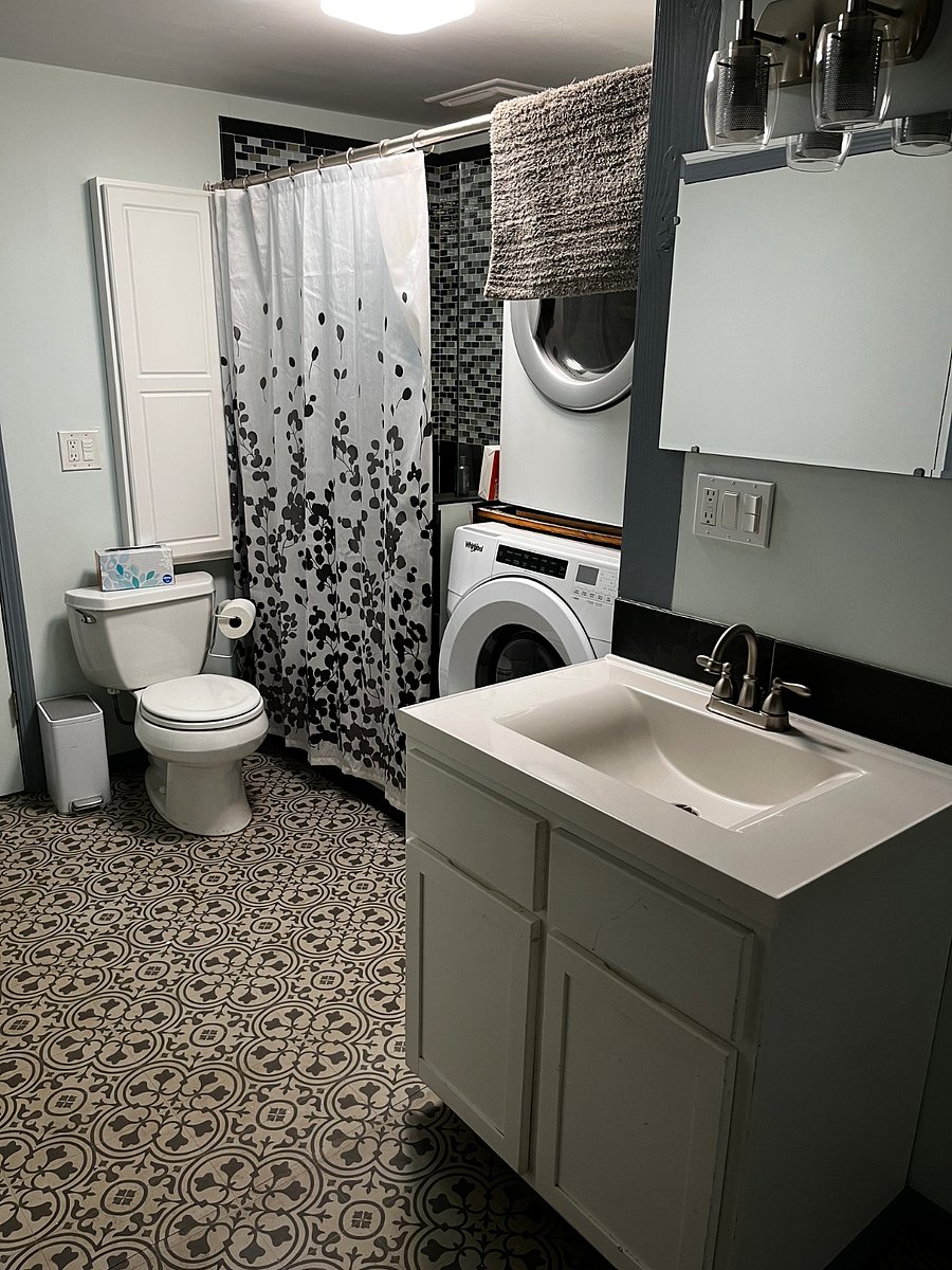 Full bathroom with shower, washer/dryer, and ironing board/iron.
