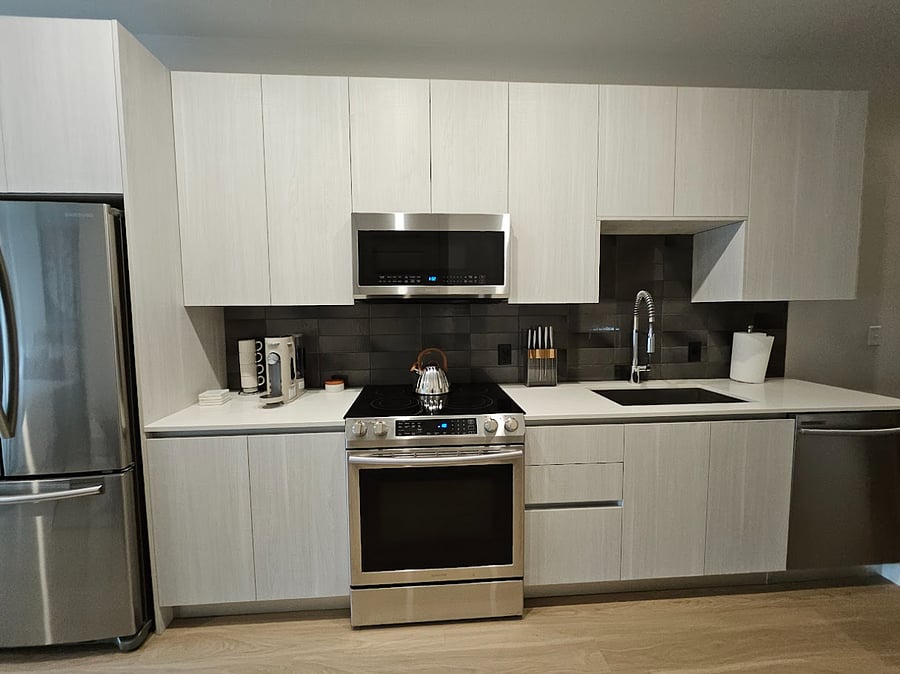 Full size upgraded kitchen with European stye cabinetry, stainless steel appliances, glass-top range, and microwave.
