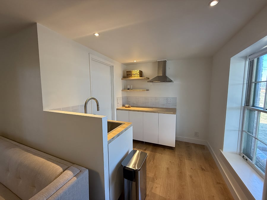 Kitchen includes apartment sized fridge, 13-in-1 air fryer oven, microwave, induction cooktop and cookware.
