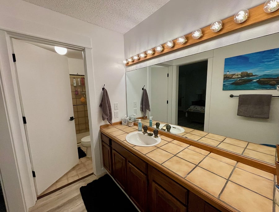 En-suite of bedroom #1, lots of counter space and vanity with chair.