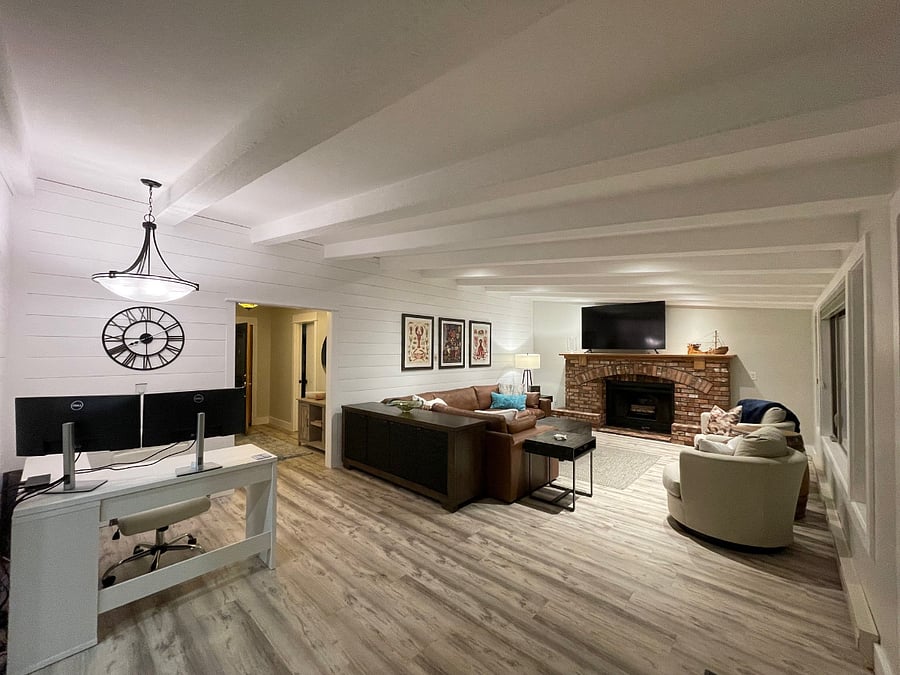 Expansive living with views to the back patio and ocean, ample seating, 70" smart TV, wood burning fireplace and adjacent office (photo take from sliding glass door). 