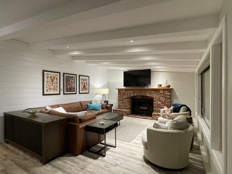 Expansive living with views to the back patio and ocean, ample seating, 70" smart TV, wood burning fireplace and adjacent office (photo take from sliding glass door). 
