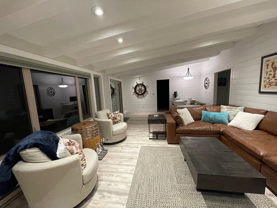 Expansive living with views to the back patio and ocean, ample seating, 70" smart TV, wood burning fireplace and adjacent office (photo take from fireplace). 
