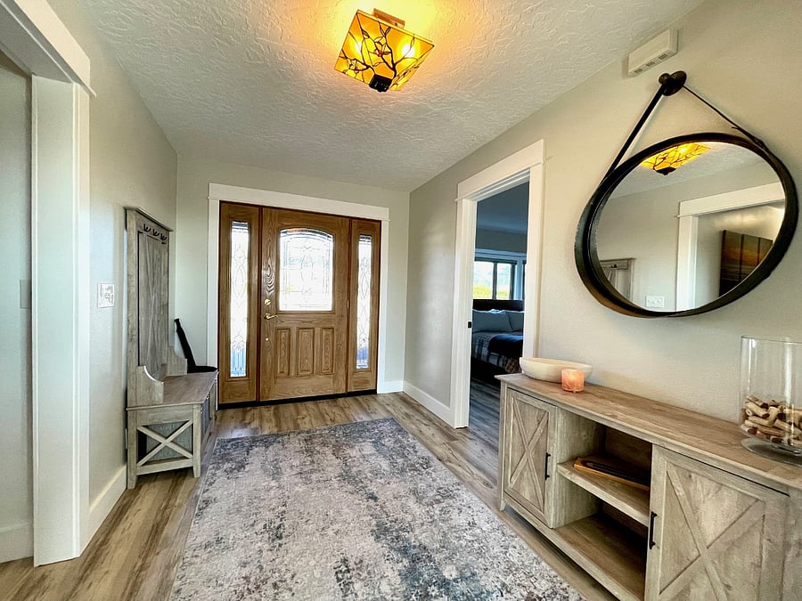 Photograph shows front door straight ahead, entry to guest bedroom #2 on the right and hallway on the left that takes you to guest bedroom #3 and bathroom #3.