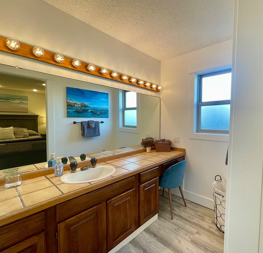 En-suite of bedroom #1, lots of counter space and vanity with chair.