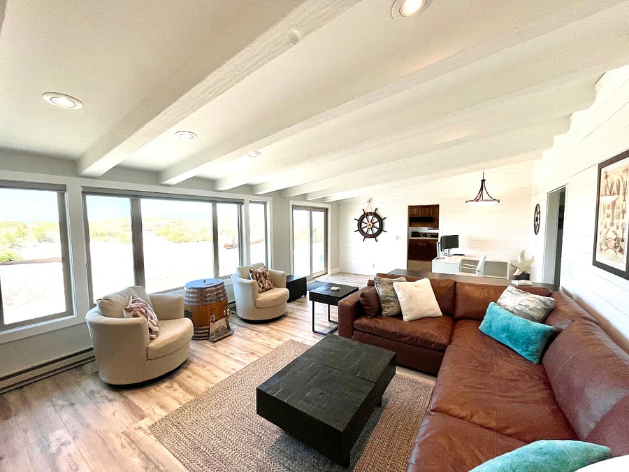Expansive living with views to the back patio and ocean, ample seating, 70" smart TV, wood burning fireplace and adjacent office (photo take from fireplace).