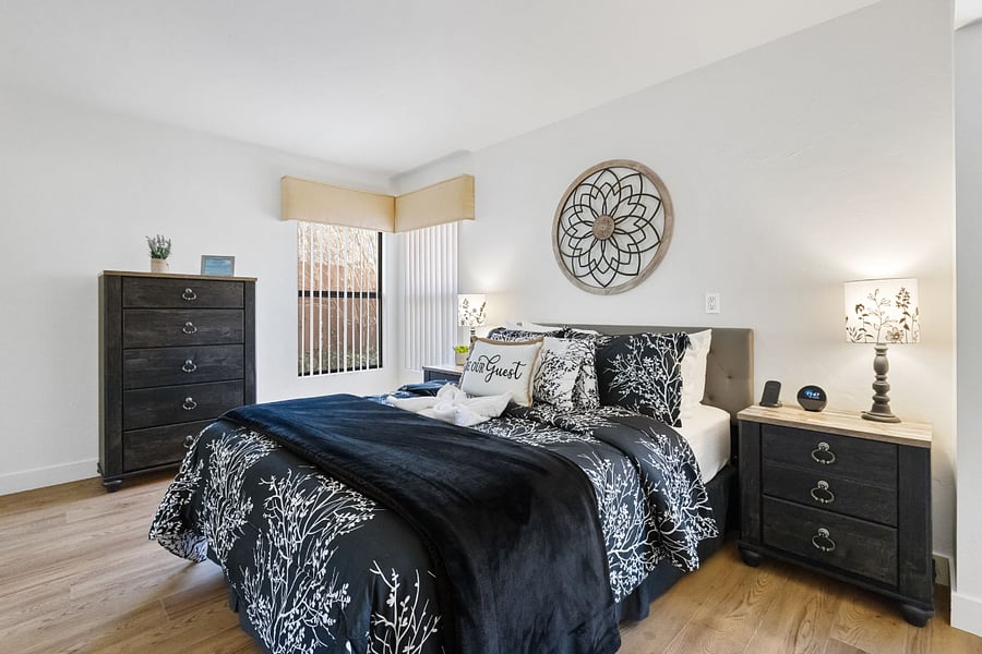A spacious master bedroom featuring adjustable king-size beds, a dedicated workspace, a private ensuite bath, and a large smart TV for ultimate comfort and convenience.