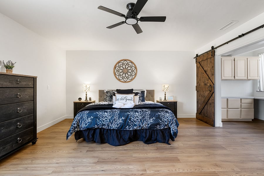 A spacious master bedroom featuring adjustable king-size beds, a dedicated workspace, a private ensuite bath, and a large smart TV for ultimate comfort and convenience.
