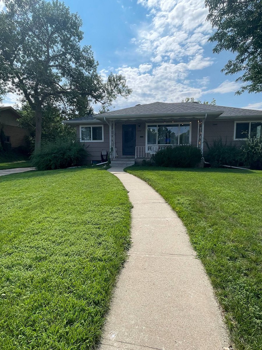Photo of the front of the house, front yard, and driveway, taken from the street in front of our Englewood home on a beautiful, sunny day in early August.