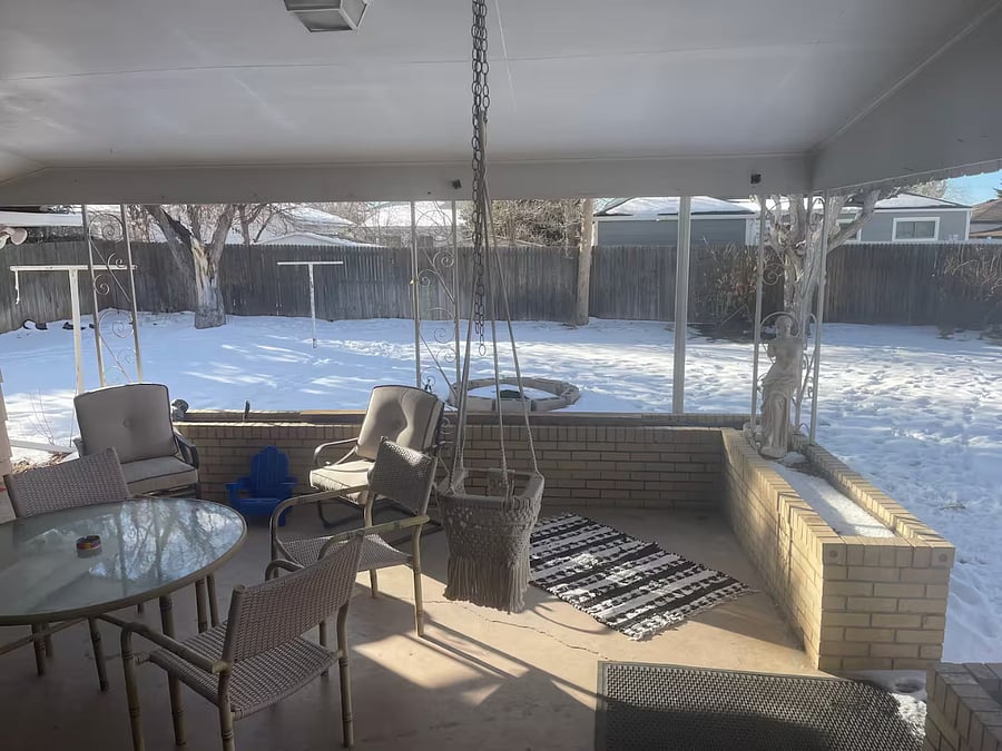 Enjoy the covered patio with a table and chairs. Patio connects to a large, fenced backyard.
