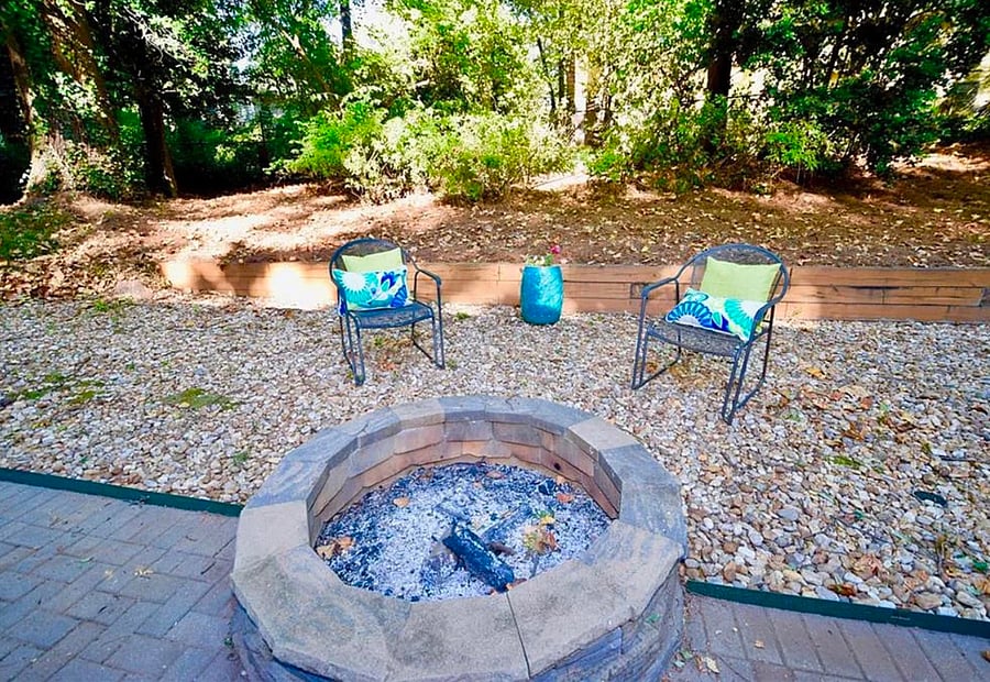 Fire pit in fenced backyard.