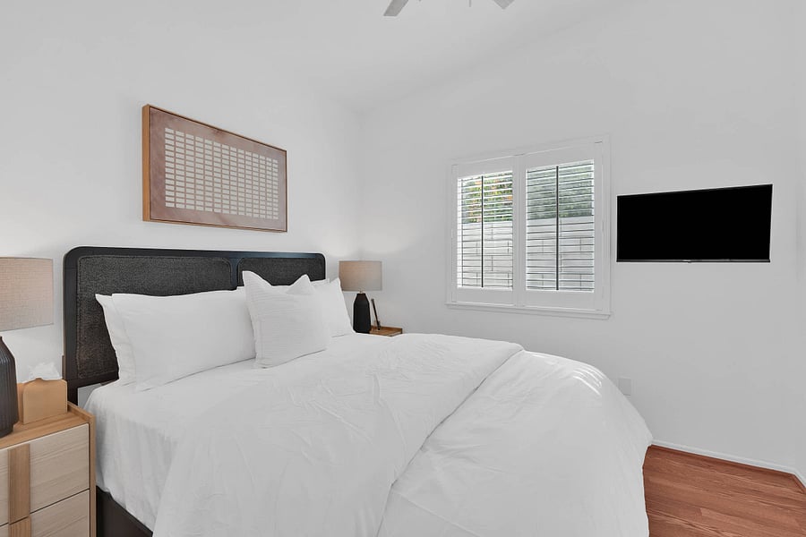 Bedroom 2 with queen bed, ceiling fan, window shutters, and smart TV