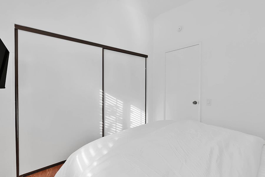 Bedroom 2 with queen bed, ceiling fan, window shutters, and smart TV