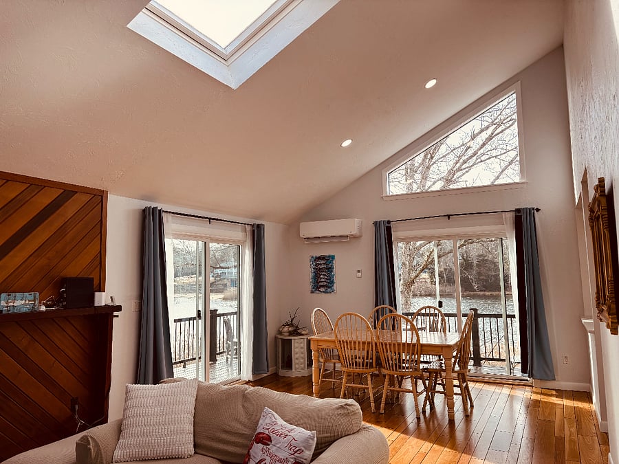 open concept living room/ dining room with water views and skylight, smart TV