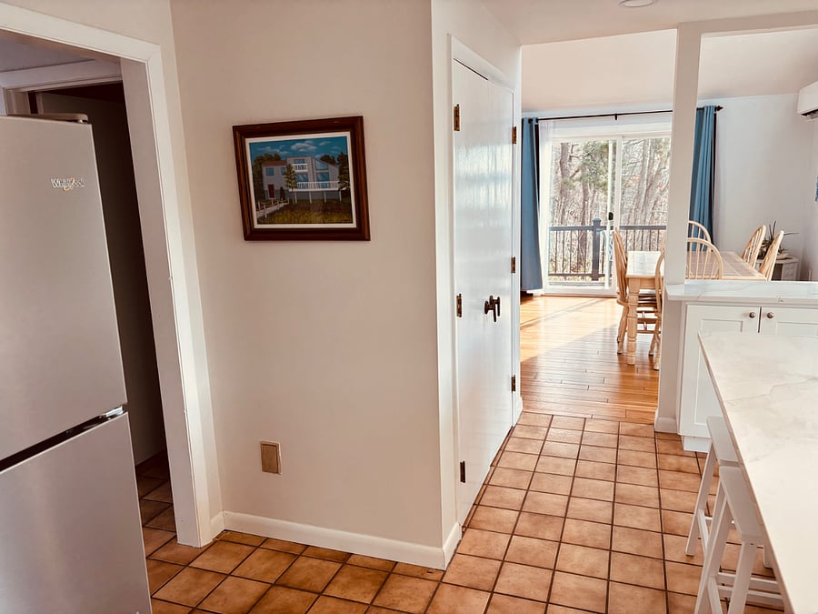 open concept first floor kitchen/ dining with 3 sliding doors that lead out to wrap-around porch