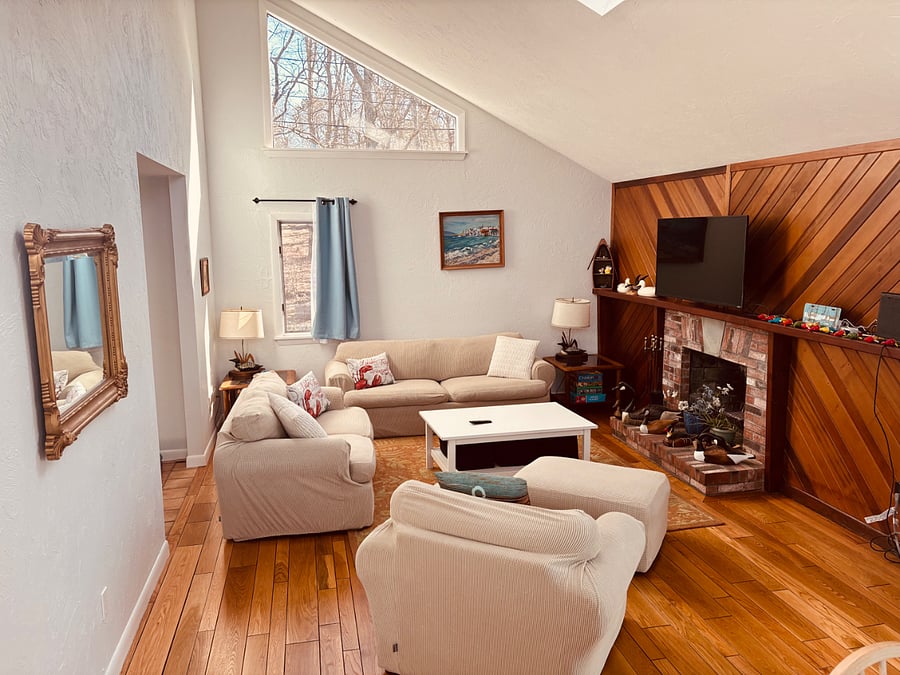large open living room/dining room with vaulted ceiling and skylight