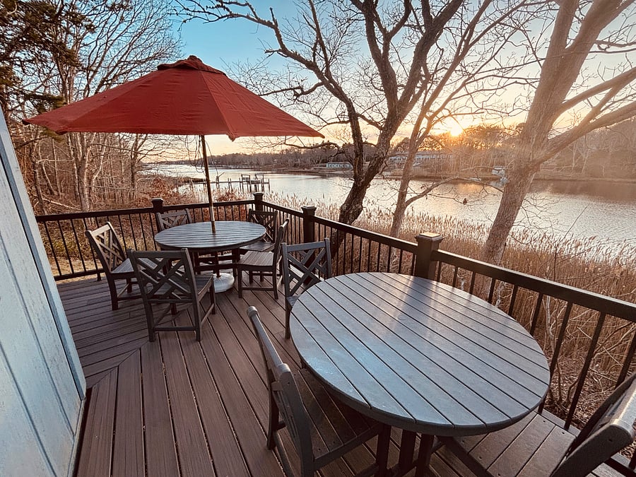 2 composite tables with seating for 8 and an umbrella, also 4 adirondack chairs for water viewing