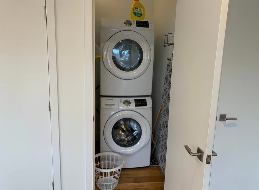 In-unit stacked washer and dryer as well as full sized ironing board.
