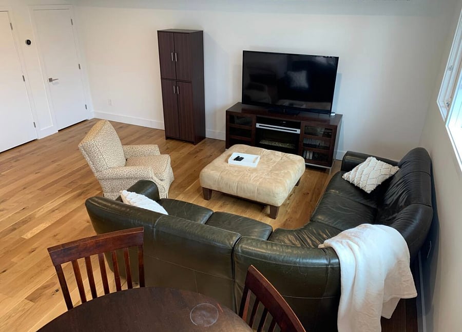 Large sectional with ottoman, chair, electric fireplace, and entertainment center completed with Smart TV.